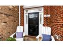 Close-up of the front door with decorative sidelights, a transom window, and comfortable seating at 8216 Indigo Row, Charlotte, NC 28277