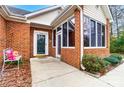 Inviting front porch with a stylish door, surrounded by lush greenery and classic brick architecture at 8405 Olde Troon Dr # 4A, Charlotte, NC 28277