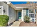 Close-up of a charming home entrance featuring a green front door, well-manicured shrubs and visible address number at 10238 Highland Creek Cir, Fort Mill, SC 29707