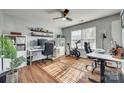 Bright, well-lit home office with wood floors, multiple desks, shelves, and a large window for natural light at 10238 Highland Creek Cir, Fort Mill, SC 29707