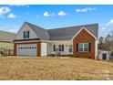 Inviting home exterior with a two-car garage, white siding, brick accents and a cozy front yard fire pit at 103 Granville Ln, Salisbury, NC 28146