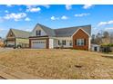 Inviting home exterior with a two-car garage, white siding, brick accents and a cozy front yard fire pit at 103 Granville Ln, Salisbury, NC 28146