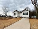 Newly built home features gray and white siding, a concrete driveway and mature trees at 1307 Signal Ave, Gastonia, NC 28052