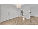 Open-concept living area with wood flooring, a modern light fixture, and lots of natural light at 1323 Queens Rd # 312, Charlotte, NC 28207