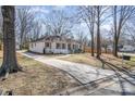 Street view of a well-maintained home with a long driveway and landscaped front yard, surrounded by mature trees at 2100 Knickerbocker Dr, Charlotte, NC 28212