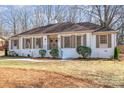 Charming single-story home featuring a brick facade, shutters, manicured landscaping and a walkway to the front door at 2100 Knickerbocker Dr, Charlotte, NC 28212