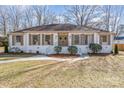 A welcoming home with a white brick facade, green wreaths on the front doors, and well-maintained landscaping at 2100 Knickerbocker Dr, Charlotte, NC 28212