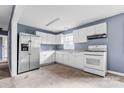 White kitchen cabinets, stainless steel appliances, and tile floor at 2209 Donnabrook Ln, Gastonia, NC 28052