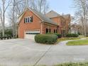 Two-car garage with large driveway and mature shrubs at 2540 Ballencourt Ln, Charlotte, NC 28226