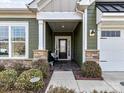 Inviting covered front porch with stone accents, tiled flooring, and a bench at 3207 Oliver Stanley Trl, Lancaster, SC 29720