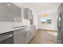 Bright kitchen features gray cabinets, quartz countertops, stainless steel dishwasher, and natural light at 4321 Bobterry Ct, Charlotte, NC 28216