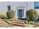 Inviting entrance with a charming blue door, brick steps, and decorative shrubs at 4923 Park Rd # D, Charlotte, NC 28209