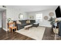 Cozy living room featuring a plush gray couch, stylish decor, and natural light at 4923 Park Rd # D, Charlotte, NC 28209