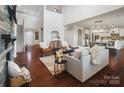 Two-story living room with hardwood floors, stone fireplace, and an open floor plan at 501 Alucio Ct, Matthews, NC 28104