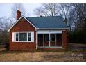 Front view of a red brick ranch house with a screened porch at 518 Oak St, Troy, NC 27371