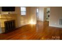 Living room featuring hardwood floors, a fireplace and view into kitchen at 518 Oak St, Troy, NC 27371