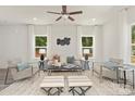 Cozy living room with neutral-toned furniture, a ceiling fan, bright windows, and a plush rug at 5812 Torrence St, Charlotte, NC 28269