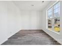 Empty room with large window and grey laminate flooring at 6518 Afterglow Dr, Indian Trail, NC 28079