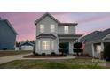 Two-story white house with landscaping and American flag at dusk at 748 Inwood Hill Dr, Gastonia, NC 28056