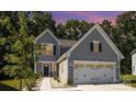 Two-story gray house with white garage doors at dusk at 1163 Ryan Meadow Dr, Monroe, NC 28110