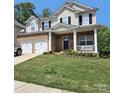Charming two-story home with a brick facade, white trim, black shutters, and a well-manicured lawn at 141 Silverspring Pl, Mooresville, NC 28117