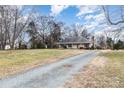 House with gravel driveway and large yard, offering privacy and space at 3219 Monte Dr, Monroe, NC 28110