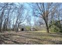 Expansive backyard showcasing mature trees, a storage shed, and a peaceful, natural setting at 3303 Reid Cir, Monroe, NC 28112