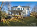 Elevated deck overlooks wooded backyard with a sloped lot at 4827 Brookridge Ne Dr, Hickory, NC 28601