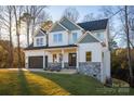 Two-story house with gray and white siding, stone accents, and a landscaped yard at 4827 Brookridge Ne Dr, Hickory, NC 28601