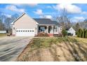 Tan house with gray roof, attached garage, and a front porch at 489 Maple Ridge Cir, Salisbury, NC 28147