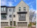 Stylish townhome with a painted brick facade, complemented by modern dark-trim windows and attached garage at 6133 Berryhill Towns Dr, Charlotte, NC 28270