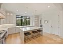 This kitchen is equipped with white cabinets, hardwood floors, and a center island with bar stool seating at 6133 Berryhill Towns Dr, Charlotte, NC 28270