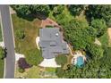 Aerial view of estate, showcasing the pool and backyard landscaping on a private, wooded lot at 110 Lynbrook Dr, Davidson, NC 28036