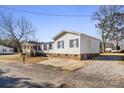 Front view of a white doublewide home with blue shutters and a gravel driveway at 111 Green Dr, Richburg, SC 29729