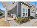 Inviting front porch with a seating area, complemented by lush landscaping and a stylish exterior at 132 Picasso Trl, Mount Holly, NC 28120