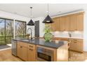 Spacious kitchen island with stone countertops, stainless appliances, and modern pendant lighting at 3132 Carol Ave, Charlotte, NC 28208