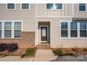 Inviting front entrance with a stained wood door, brick accents, and well-manicured landscaping at 604 Amalfi Dr, Davidson, NC 28036