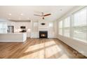 Open-concept living room with a fireplace, hardwood floors, and a view into the modern kitchen at 604 Amalfi Dr, Davidson, NC 28036