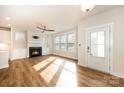 Bright and airy living room with a cozy fireplace, hardwood floors, and a wall of windows at 604 Amalfi Dr, Davidson, NC 28036