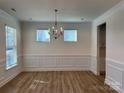 Bright dining room with hardwood floors, wainscoting, and chandelier at 6911 Fauna Dr # 60, Charlotte, NC 28215