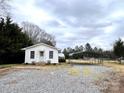 Front view of a simple white house with gravel driveway and carport at 115 Hillcrest Dr, Bessemer City, NC 28016