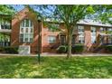 Brick townhome exterior with well-maintained lawn, mature trees and steps leading up to the front door at 128 Steinbeck Way # E, Mooresville, NC 28117