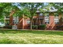 Brick townhome exterior with well-maintained lawn, mature trees and steps leading up to the front door at 128 Steinbeck Way # E, Mooresville, NC 28117