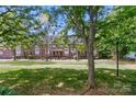 Exterior shot of the brick townhome complex with well-maintained lawn, mature trees and lampposts at 128 Steinbeck Way # E, Mooresville, NC 28117
