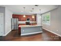 Spacious kitchen featuring stainless steel appliances, a large island, and cherry wood cabinets for ample storage at 128 Steinbeck Way # E, Mooresville, NC 28117