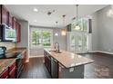Bright, open kitchen with an island, stainless steel appliances, and a view to the living area with soaring ceilings at 128 Steinbeck Way # E, Mooresville, NC 28117