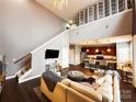 Spacious living room with high ceilings, adjoining kitchen, and modern decor at 128 Steinbeck Way # E, Mooresville, NC 28117