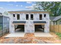 Under construction of a new modern style home with a black roof and two garage doors at 1409 Downs Ave, Charlotte, NC 28205