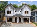 Under construction of a new modern style home with a black roof and two garage doors at 1409 Downs Ave, Charlotte, NC 28205