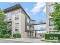 Modern condo building featuring connecting walkways and manicured landscaping with a mix of stone and metal exterior finishes at 2116 Mcclintock Rd, Charlotte, NC 28205